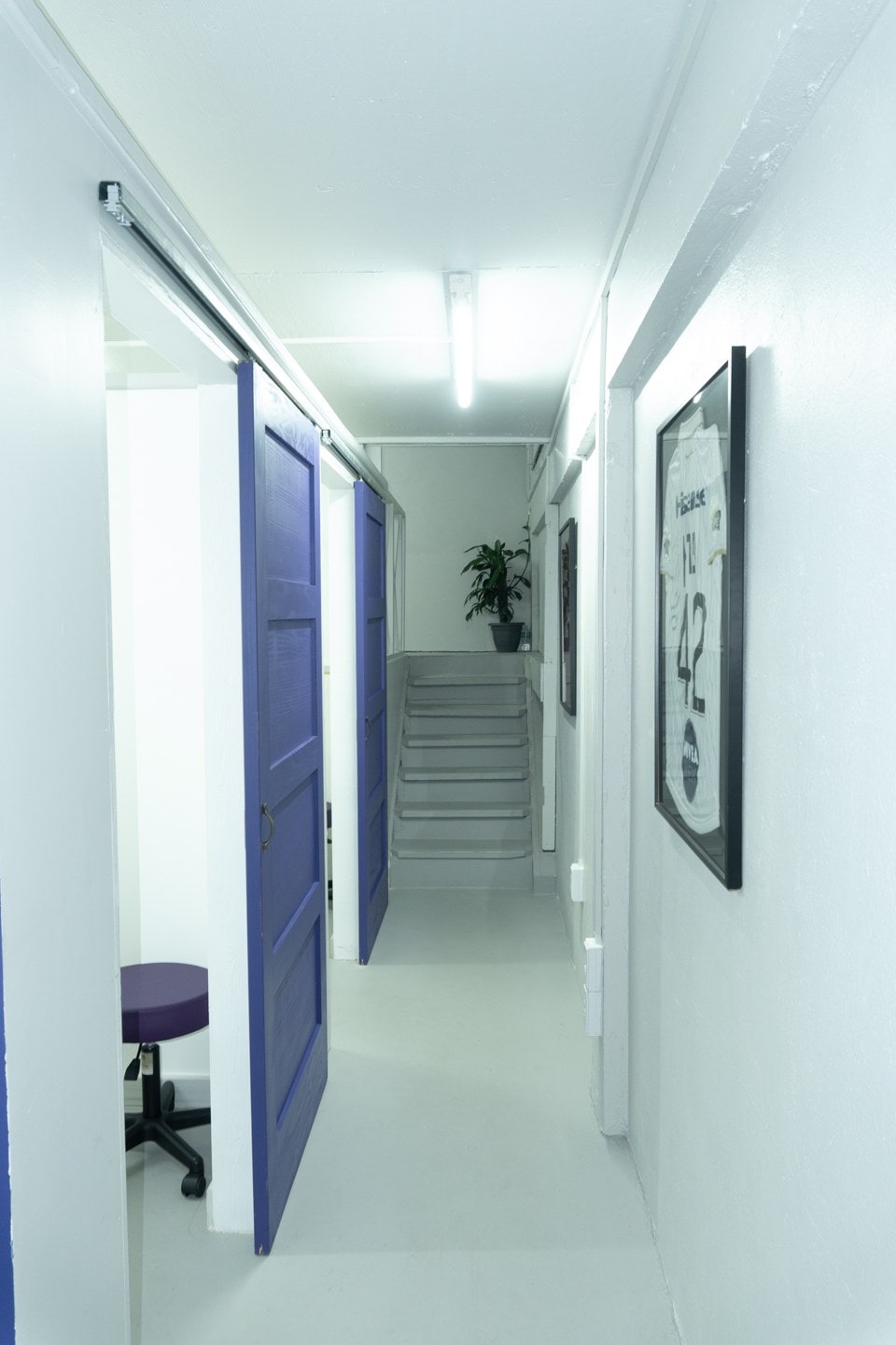 Inside the POPS clinic: a bright corridor with the practice's signature blue treatment-room doors