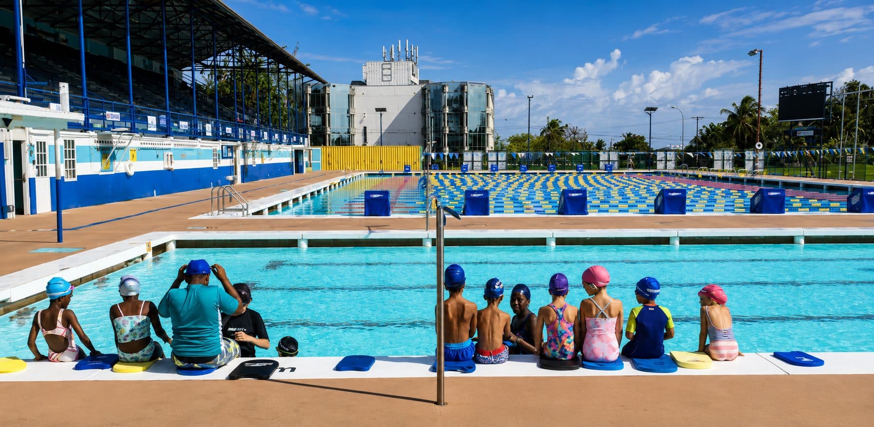 Children at a POPS aquatic programme session, sitting at the poolside